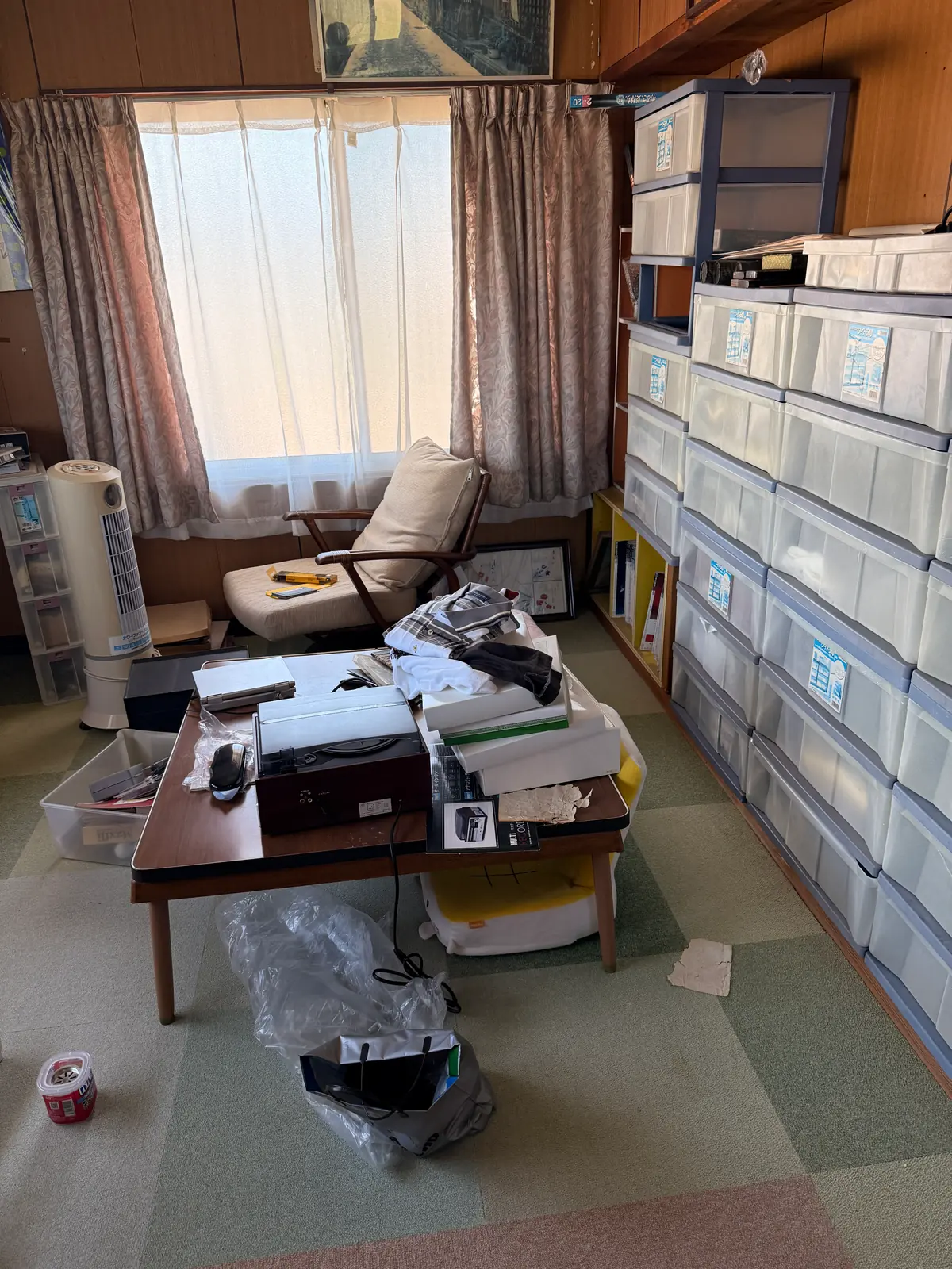 収納ケースと衣類や箱が置かれた実家の部屋